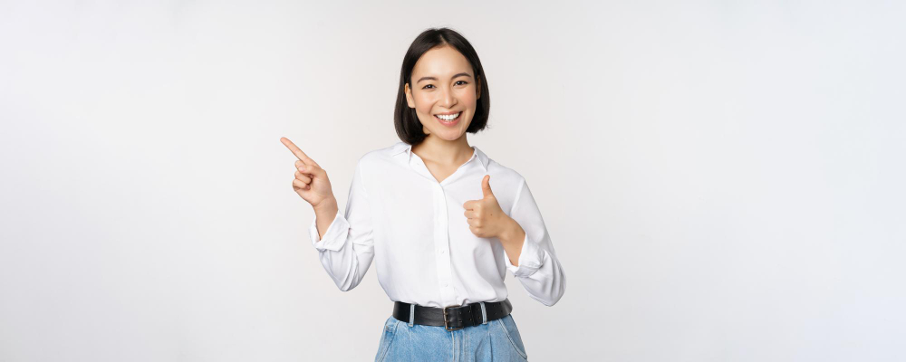 image-young-asian-business-woman-smiling-while-pointing-finger-left-showing-thumbs-up-recommending-product-praise-standing-white-background